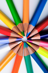 Naklejka premium Color crayons pointing into the center