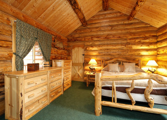 Cozy bedroom in log cabin house