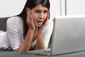 Frau schaut auf entsetzt auf ihr Laptop