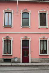 Fototapeta na wymiar Facciata palazzo rosa con finestre