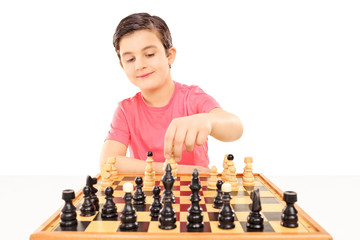 Young boy playing chess seated at a table © Ljupco Smokovski