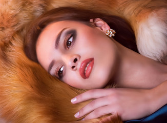Naklejka premium Portrait of beautiful young woman with makeup in fur