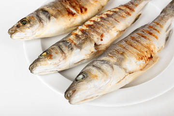 Delicious grilled fish on plate on table close-up