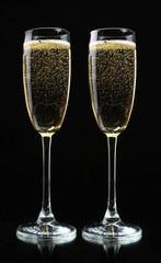 Glasses of champagne, on black background