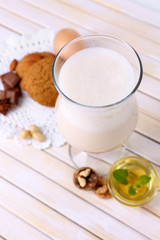 Eggnog with cookies on wooden table