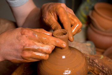 hands of a potter, creating an earthen jar