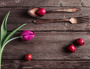 vintage silverware fork and spoon with easter eggs on old wooden