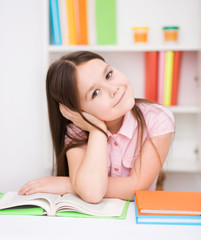 Little girl is reading a book