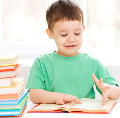 Little boy is reading a book