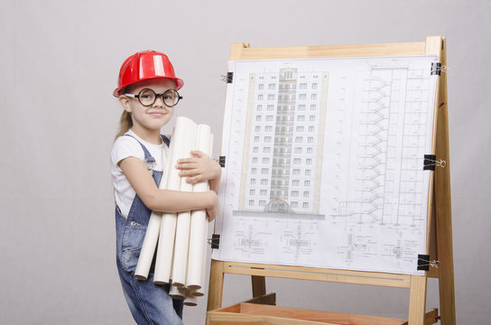 ребенок инженер стоит с чертежами у доски