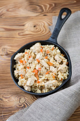 Pilaf with chicken in a frying pan, view from above