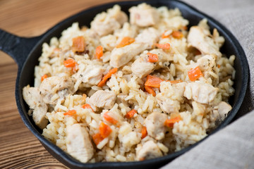 Pilaf with chicken in a frying pan, close-up