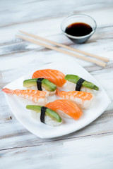 Sushi with salmon, shrimp and avocado, vertical shot