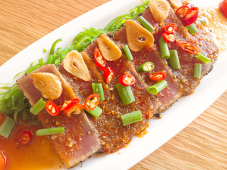 smoke tuna spicy with salad frieze on wooden table