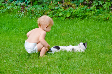 Baby and the cat on the lawn