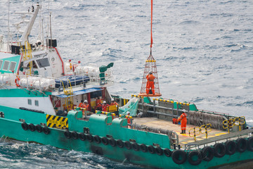 Workers are lifted by the crane to the offshore platform