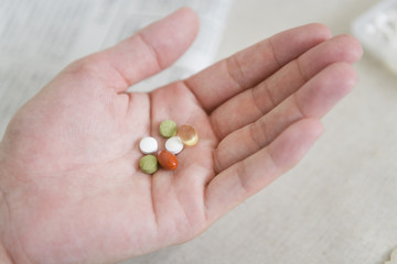 hand of man taking supplement in his hand
