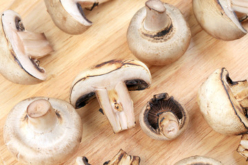 White mushrooms on wooden board.