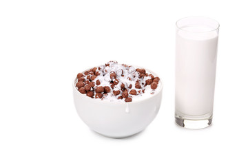 Bowl of chocolate cereal and milk glass.