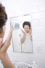 Fototapeta premium man patting face lotion on cheek