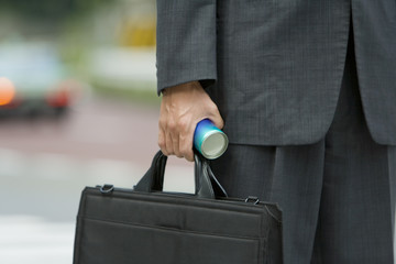 hand of businessman with bag and canned drink