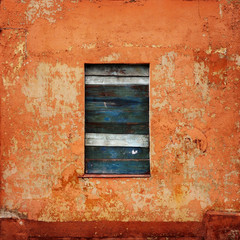 orange wall with a board up window