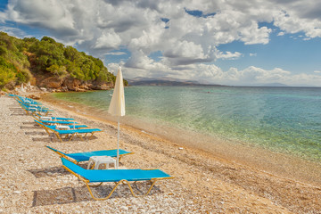 Empty beach Lounge chairs under bright sunlight
