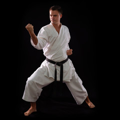 karate man with black belt posing, champion of the world on blac © Khorzhevska