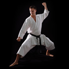 karate man with black belt posing, champion of the world on blac © Khorzhevska