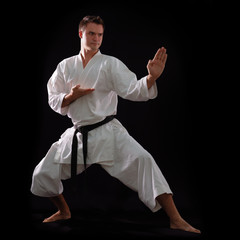 karate man with black belt posing, champion of the world on blac © Khorzhevska