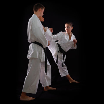 fighting karate couple, man and woman with black belts - champio