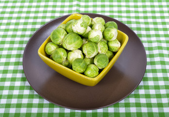 Brussels sprouts in a brown plate on green towel