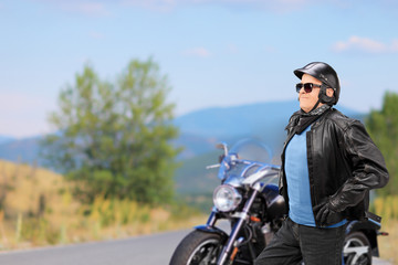 Fototapeta na wymiar Mature biker walking in front of his motorbike