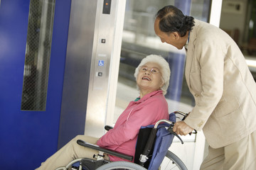 wheelchaired husband and wife using an elevator