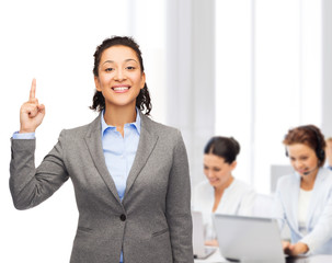 smiling businesswoman with her finger up at office