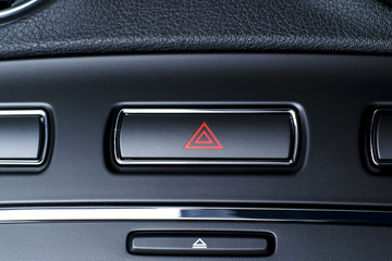 Vehicle hazard warning flashers button with red triangle.