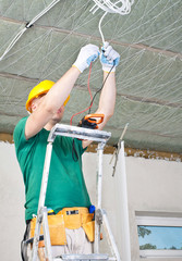 electrician with multimeter checking voltage