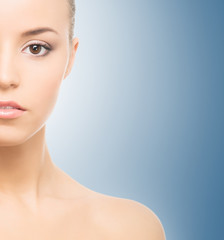 Fototapeta premium Portrait of a young, beautiful and healthy girl over blue