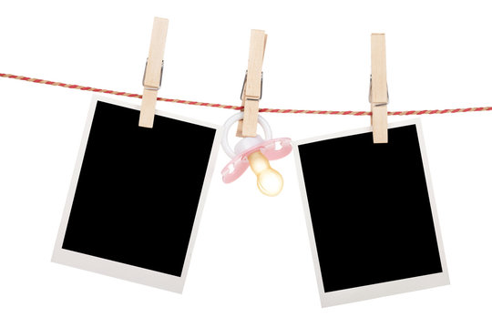 Instant photo frames and pacifier hanging on the clothesline