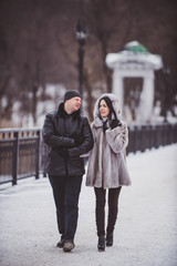 man and woman on a background of trees in winter