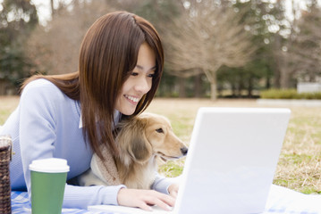 woman operating PC and dog