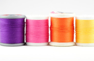 Four spools of thread on white