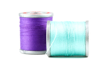 Two small spools of thread, on white