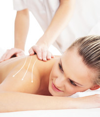 Back of a woman getting spa treatment from a therapist