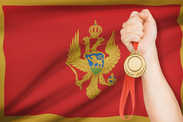 Medal in hand with flag on background - Montenegro
