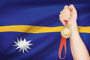 Medal in hand with flag on background - Republic of Nauru
