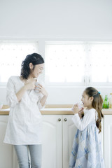 mother and daughter holding mug in hand