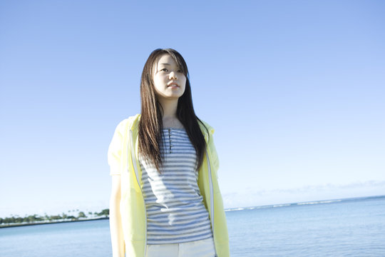 Woman Standing Still In Front Of Sea