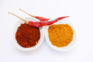Cayenne pepper and curry powder on white background.