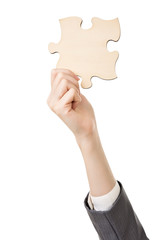 Business woman's hand holding a jigsaw puzzle